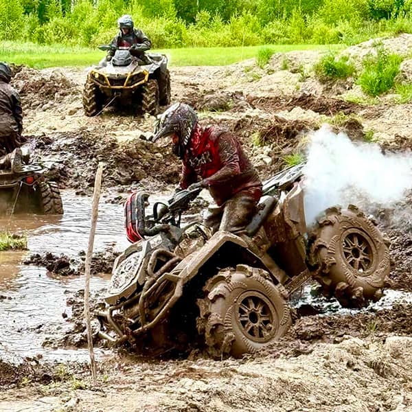Förare kör ATV genom lera på testbanan